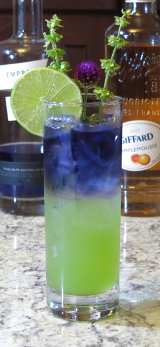 Royal Basil Smash Cocktail with lime wheel and basil blossom for garnish