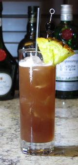Singapore Sling cocktail served over ice with pineapple and cherry garnish
