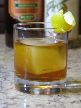 Talent Scout cocktail in a rocks glass with a lemon twist garnish